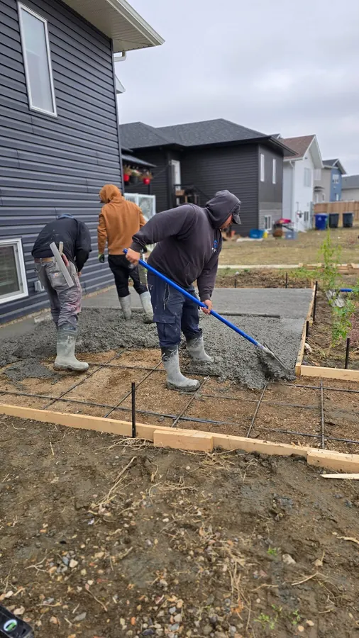Concrete finisher working on a fresh residential slab in Saskatoon