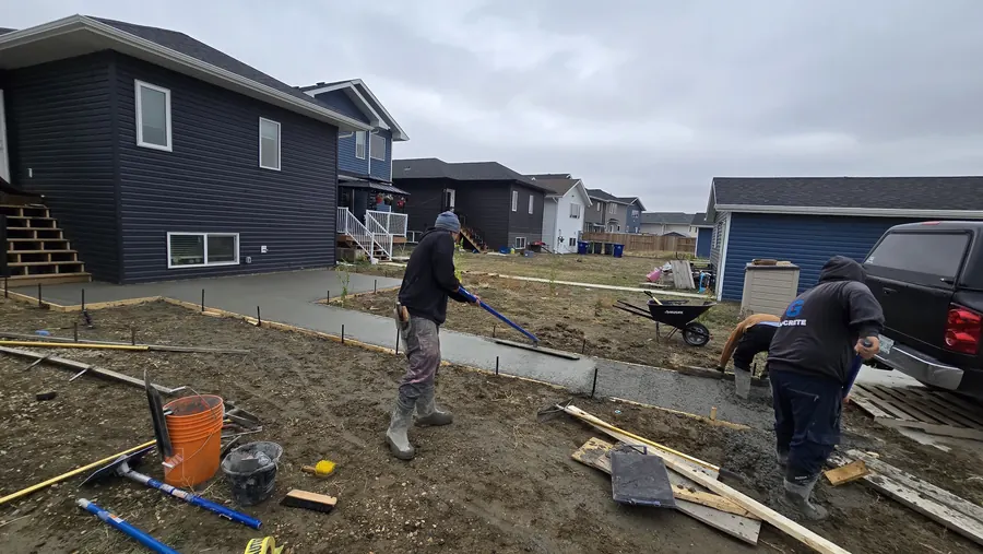 Crew finishing residential concrete flatwork in Saskatoon
