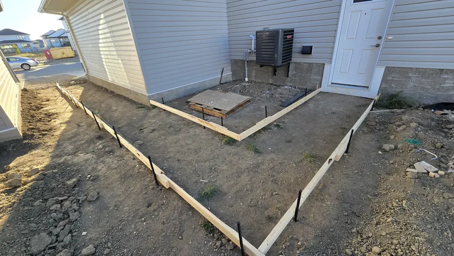 Concrete path and patio formwork prepared beside a Saskatoon home
