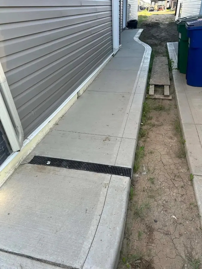 Concrete walkway beside a Saskatoon home with a grated drainage channel