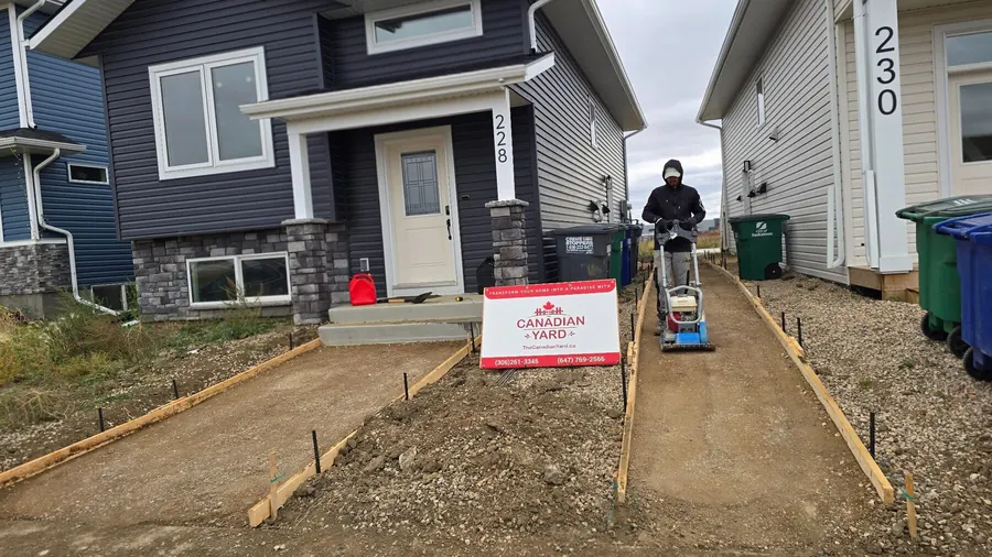 Residential concrete walkway formwork with project sign in Saskatoon