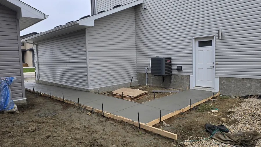 Concrete walkway formwork prepared along a Saskatoon property
