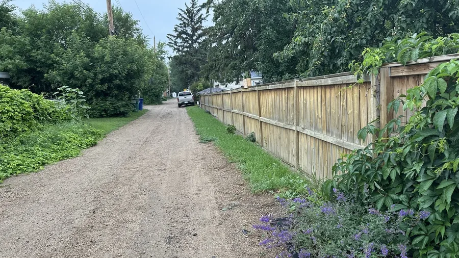 Landscape view of a long wood fence along a Saskatoon alley